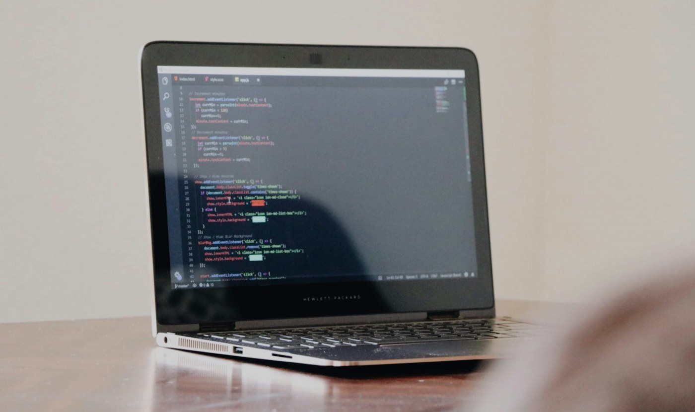 Computador portátil con código en pantalla sobre un escritorio